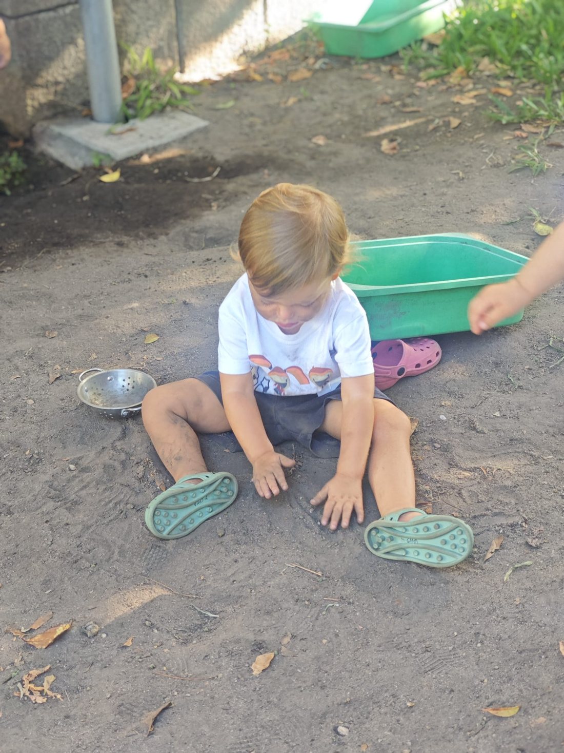 Criança sentada na terra do jardim